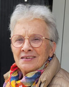 Image de l'auteur Eliane Falcon portant une veste marron clair et un foulard coloré autour du cou.