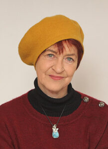 Photo de Marie-Noëlle Fargier avec un bonnet orange, un pull rouge avec en dessous un tee-shirt noir.